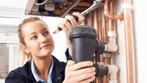 woman plumber working on a water filtration installation